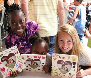 Three young, female Ryan House volunteers with homemade picture frames