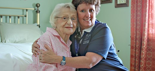 Female nurse hugging female patient