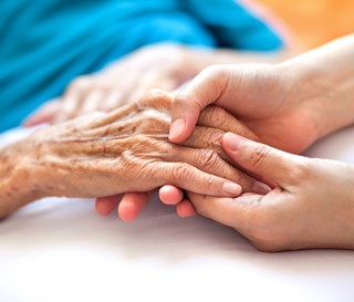 Young hands holding elderly hands