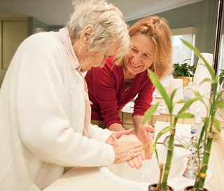 Gillian Hamilton, MD, helps a dementia patient wash her hands