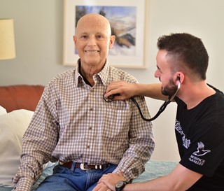 John Hardinson Nurse takes heart rate of patient