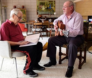 Music volunteer John Johnson playing guitar for dementia patient Ed Korrick
