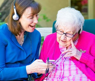 Maribeth Gallagher enjoying music with patient Sue Crawford at Gardiner Home