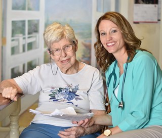 Caregiver going over paperwork of female patient