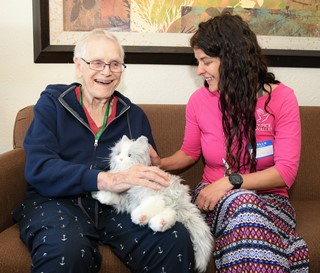 Social worker Michelle Bales visits with patient Walter “Wally” Brown and his mechanical cat, Sweetheart.