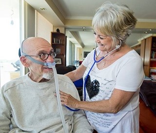 Nurse Judy LeBrun checks heart rate of patient James Showkeir