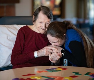 Caregiver kissing hand of dementia patient