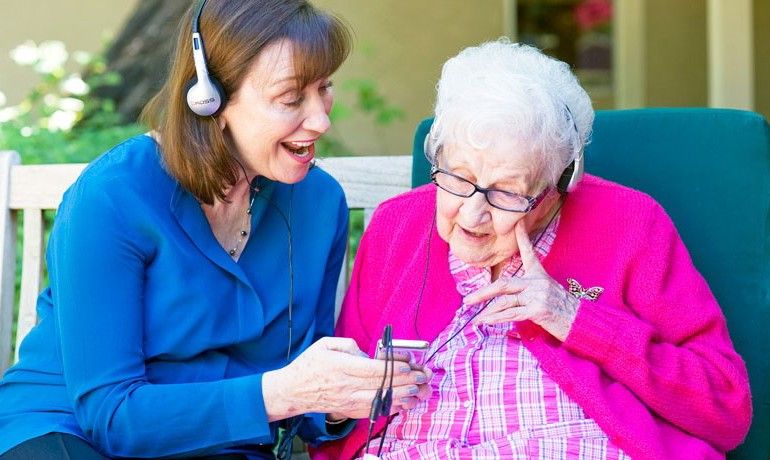 Maribeth Gallagher, DNP with patient listening to music