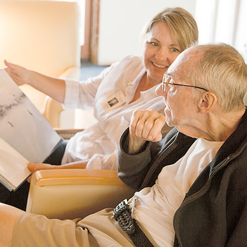 Nurse reading a book to a male dementia patient