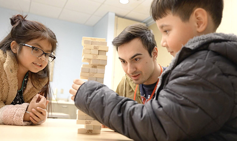 New Song Center volunteer and children playing with blocks