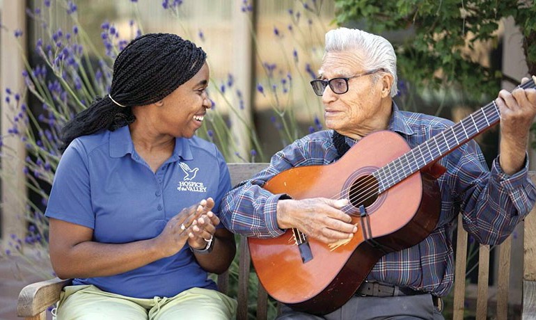Patient Feliciano playing guitar with Danae Holt, CNA