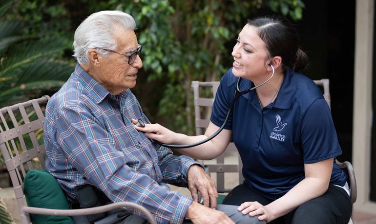 Nurse checking patient's heart with stethoscope