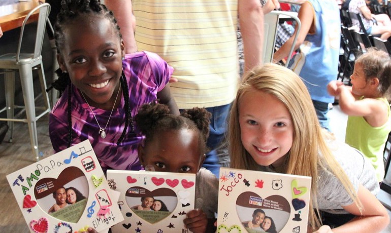 Children showing picture frames they made at New Song Center event